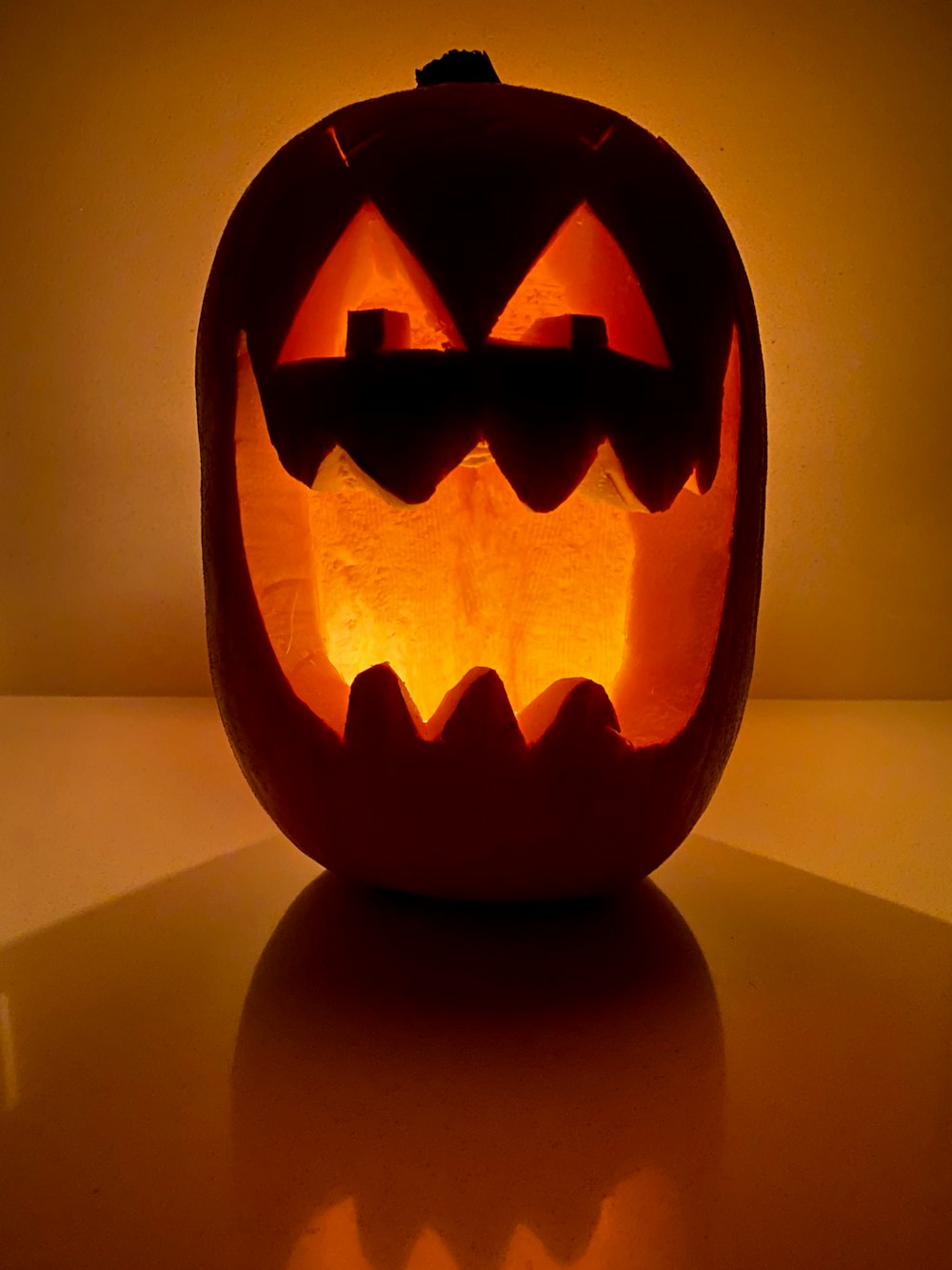 Jack O Lantern Lampe auf weißem Tisch eingeschaltet