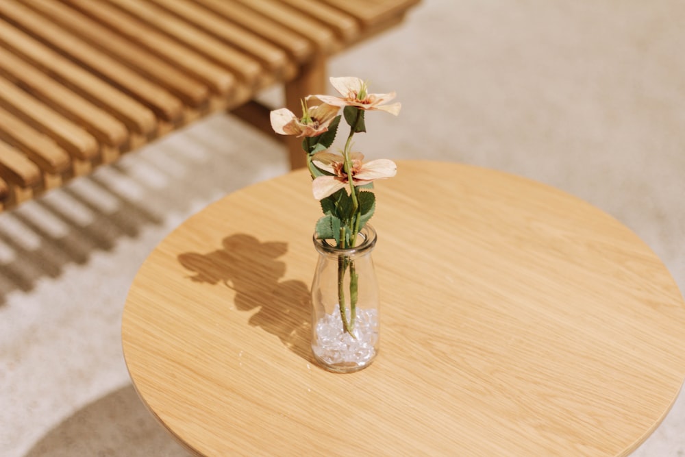 green plant in clear glass vase on brown wooden table