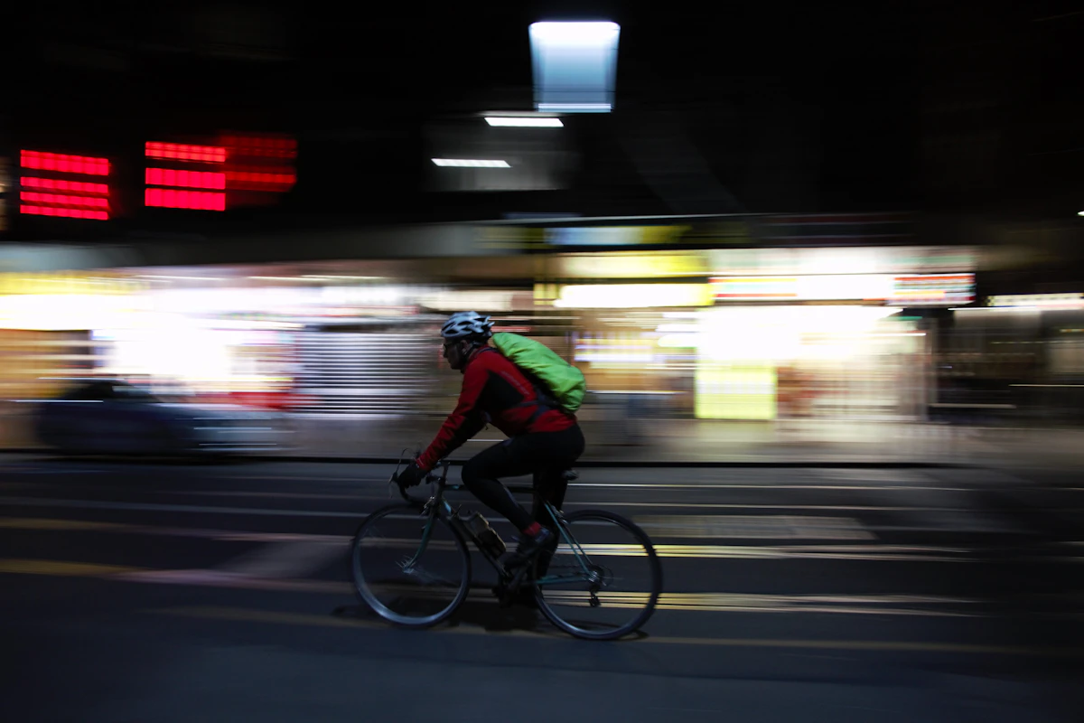 man in green shirt riding bicycle on road during night time