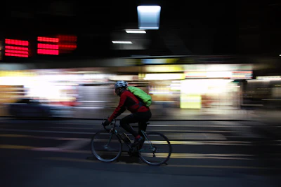 man in green shirt riding bicycle on road during night time