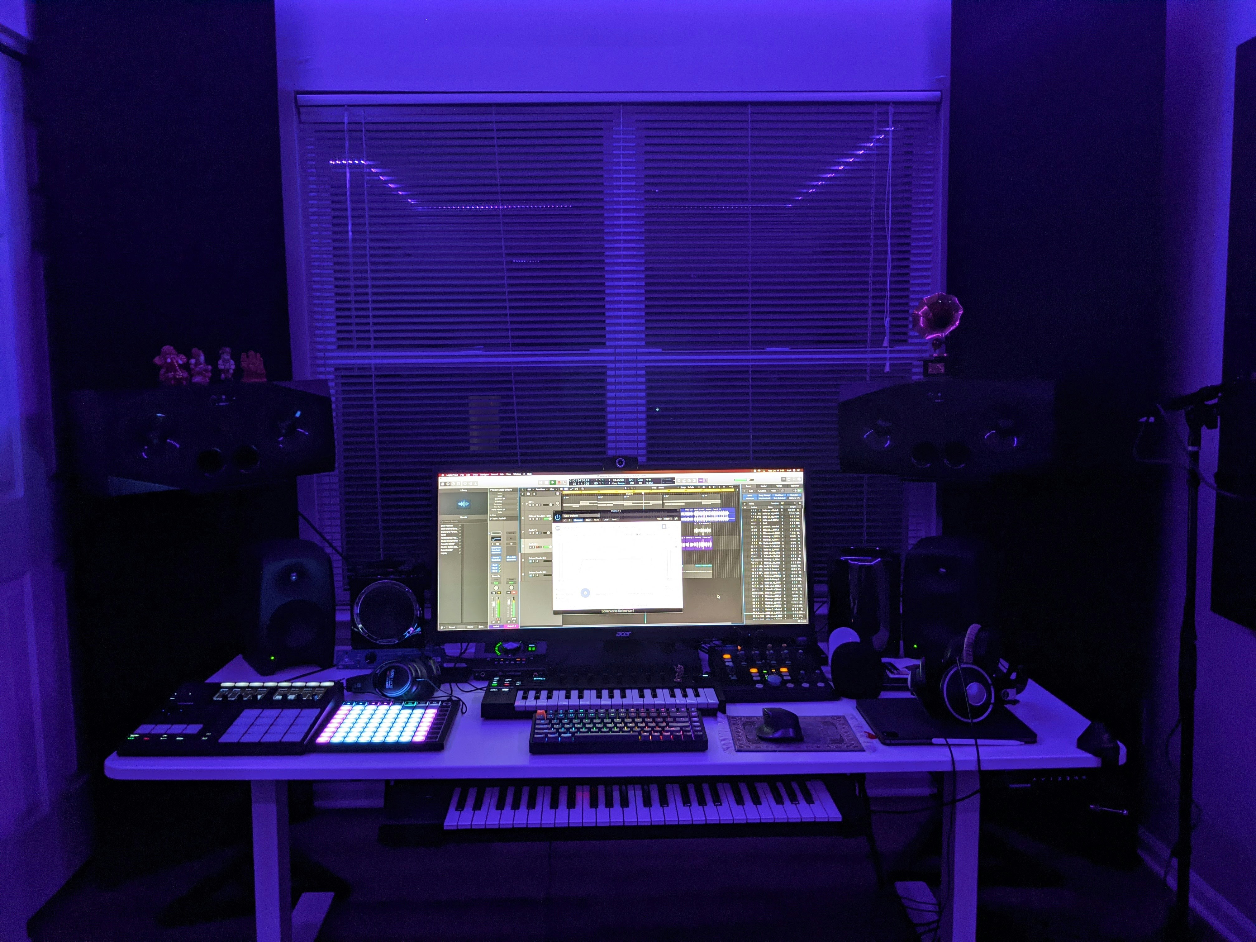Music production studio with synthesizers and ambient purple lighting