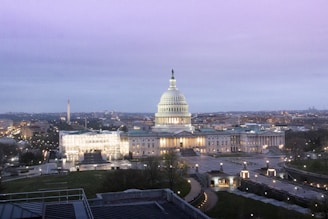 A dynamic cityscape of Washington DC at dusk, highlighting government buildings with vibrant lighting.