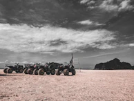 A panoramic view of the beach with multiple ATVs lined up, ready for the next adventure.