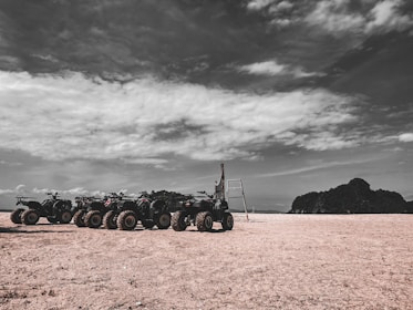 A lineup of sturdy ATVs parked outdoors on a sunny day.
