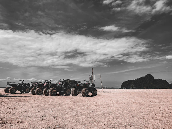 A group of friends riding ATVs through rugged Texas trails under a bright blue sky.