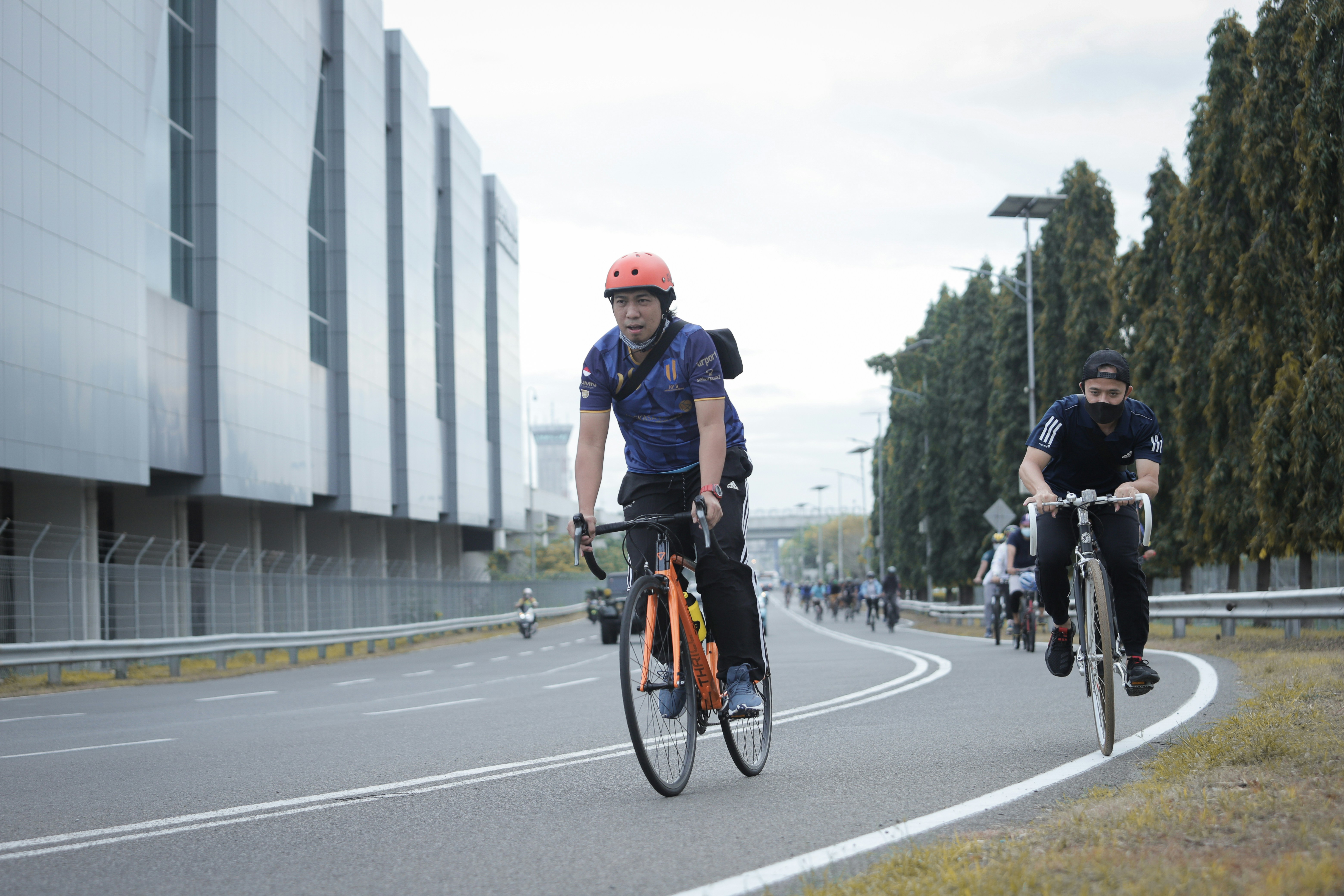 man in black jacket riding bicycle on road during daytime