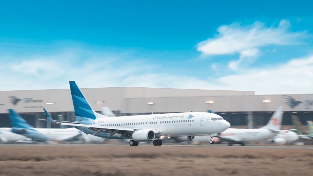 Avión de pasajeros blanco en campo marrón bajo cielo azul durante el día