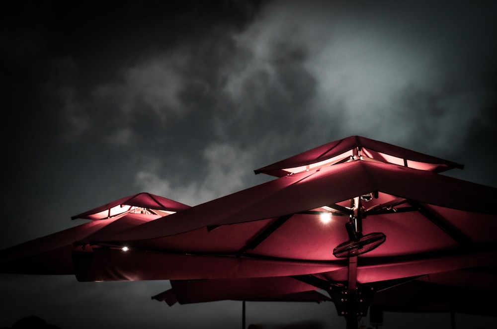 red umbrella under gray clouds