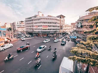 A vibrant city street in Brazil with cars and motorcycles.