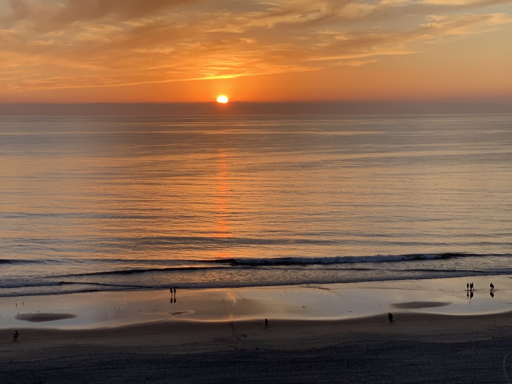 sea waves crashing on shore during sunset