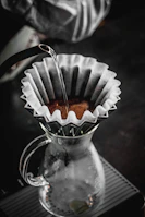 An elegant pour-over setup with glass carafe and kettle, bathed in warm natural light.