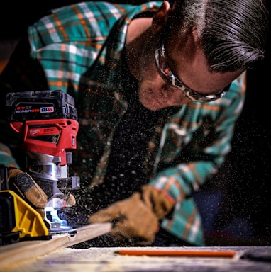 man in green and black plaid long sleeve shirt holding red and black cordless hand drill