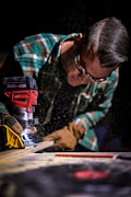 Tradesperson in safety glasses operating power tool