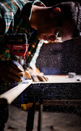 person holding orange and black power tool