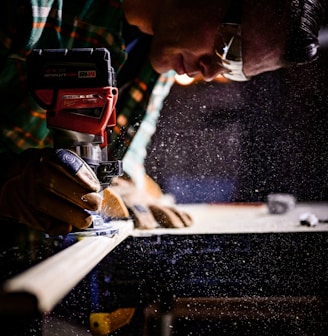 person holding orange and black power tool