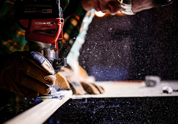 person holding orange and black power tool