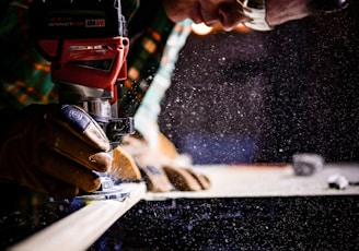 person holding orange and black power tool