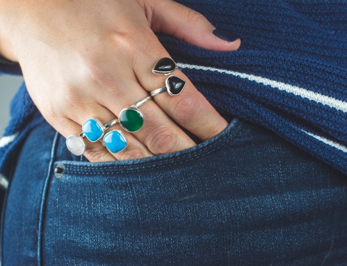 person wearing silver teal and green gemstone ring