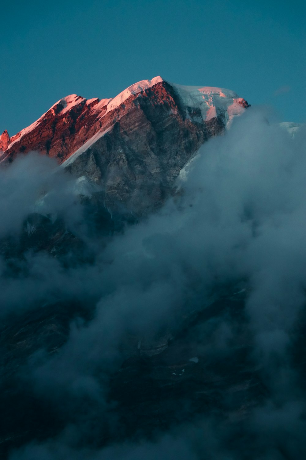 Montaña marrón y gris cubierta de nubes