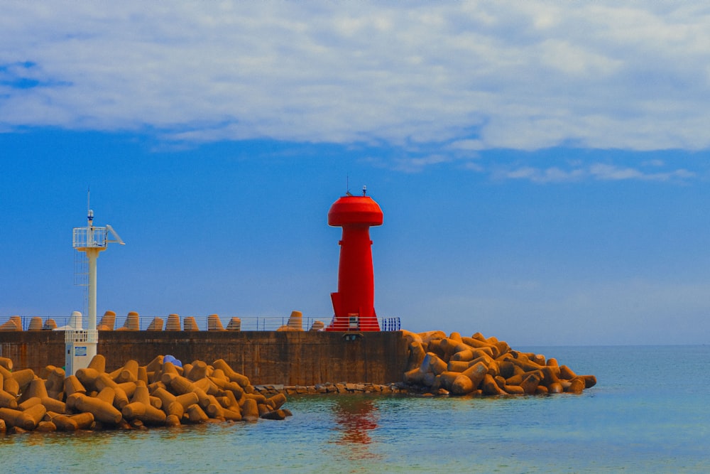 red and white lighthouse near body of water during daytime