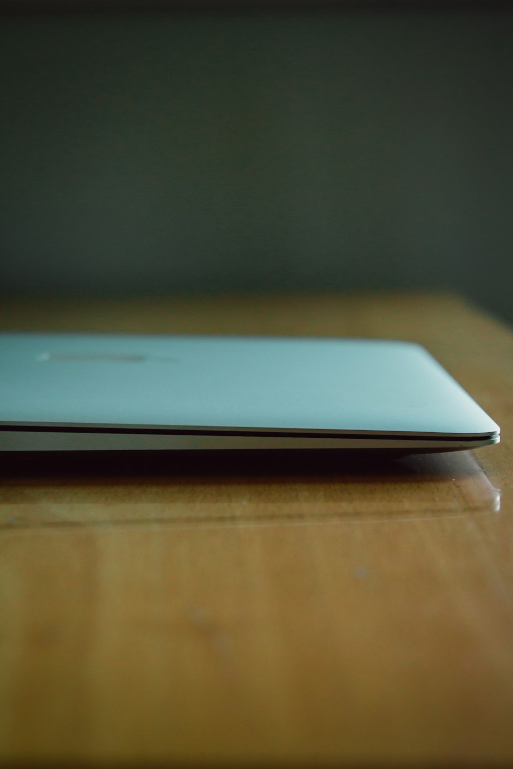 silver macbook on brown wooden table