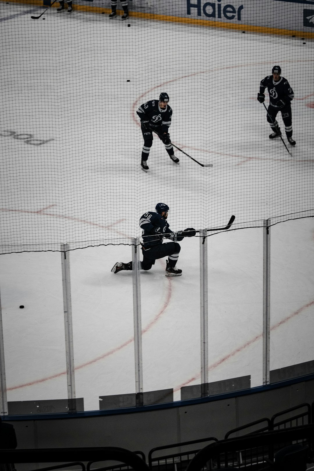 man in black and white ice hockey jersey riding on ice hockey stick