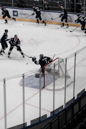Coach Dave demonstrating stick handling drills on the rink with focused players watching.