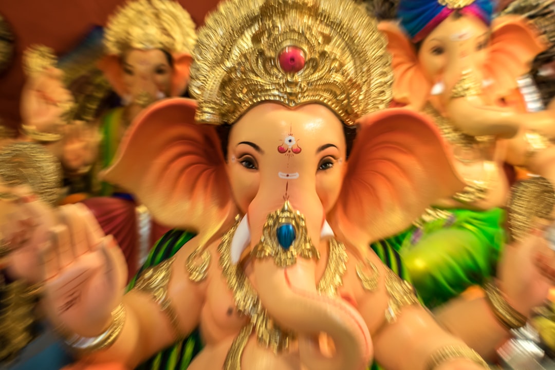 gold hindu deity figurine on table, A beautiful idol of Lord Ganesha