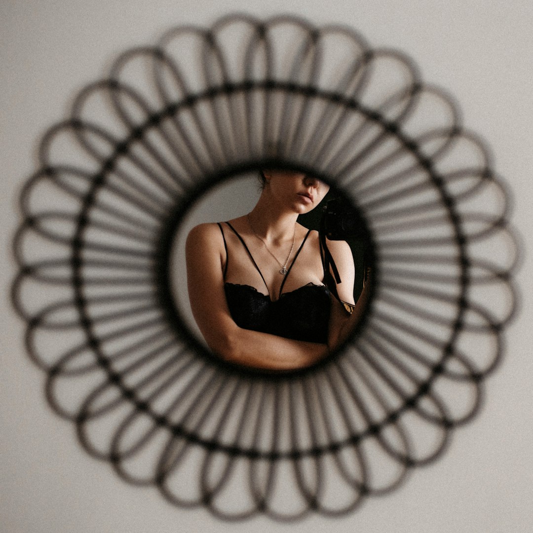 woman in black brassiere lying on white spiral spiral light