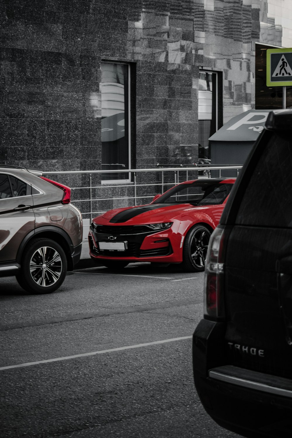 red car parked beside gray building