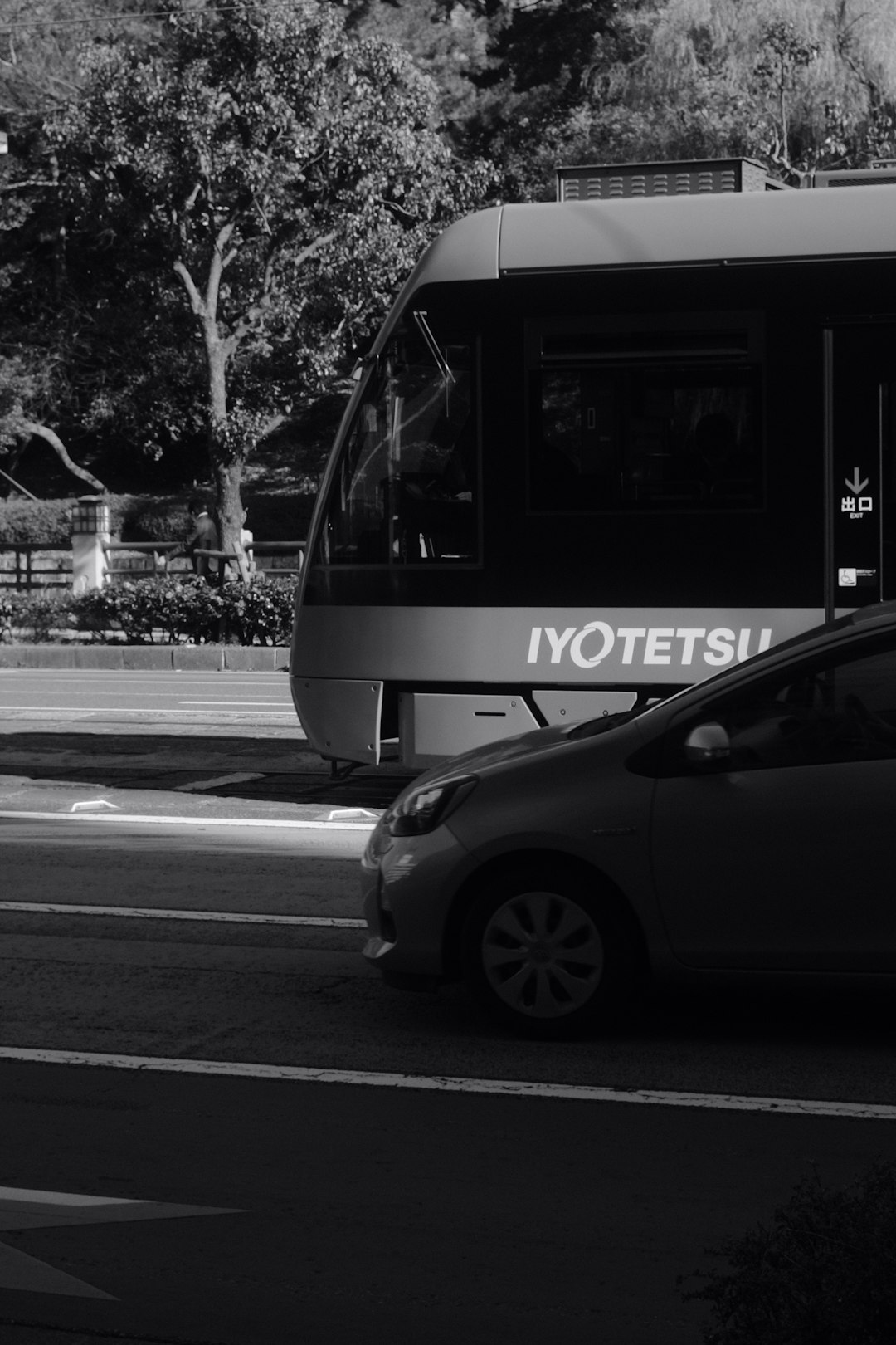 grayscale photo of white and black bus on road