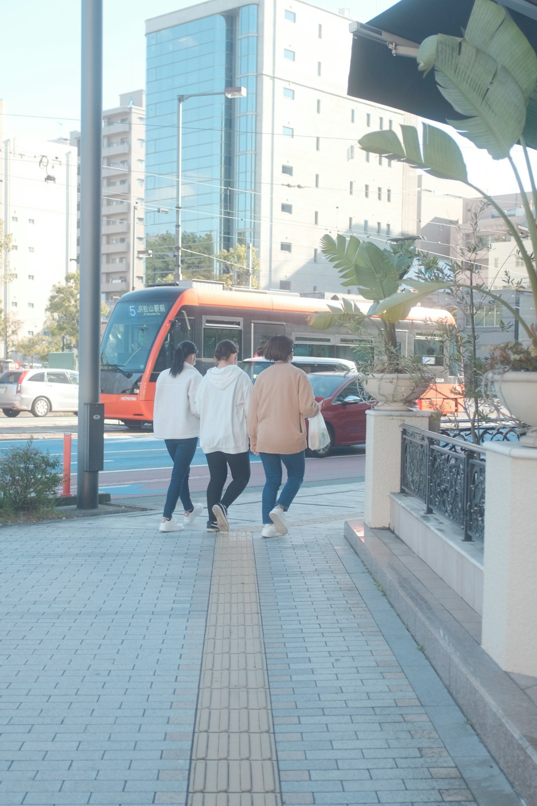 man in white shirt and woman in white shirt walking on sidewalk during daytime