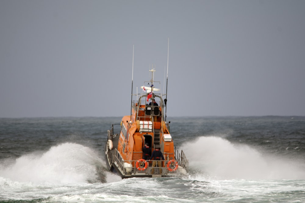 orange and white boat on sea during daytime