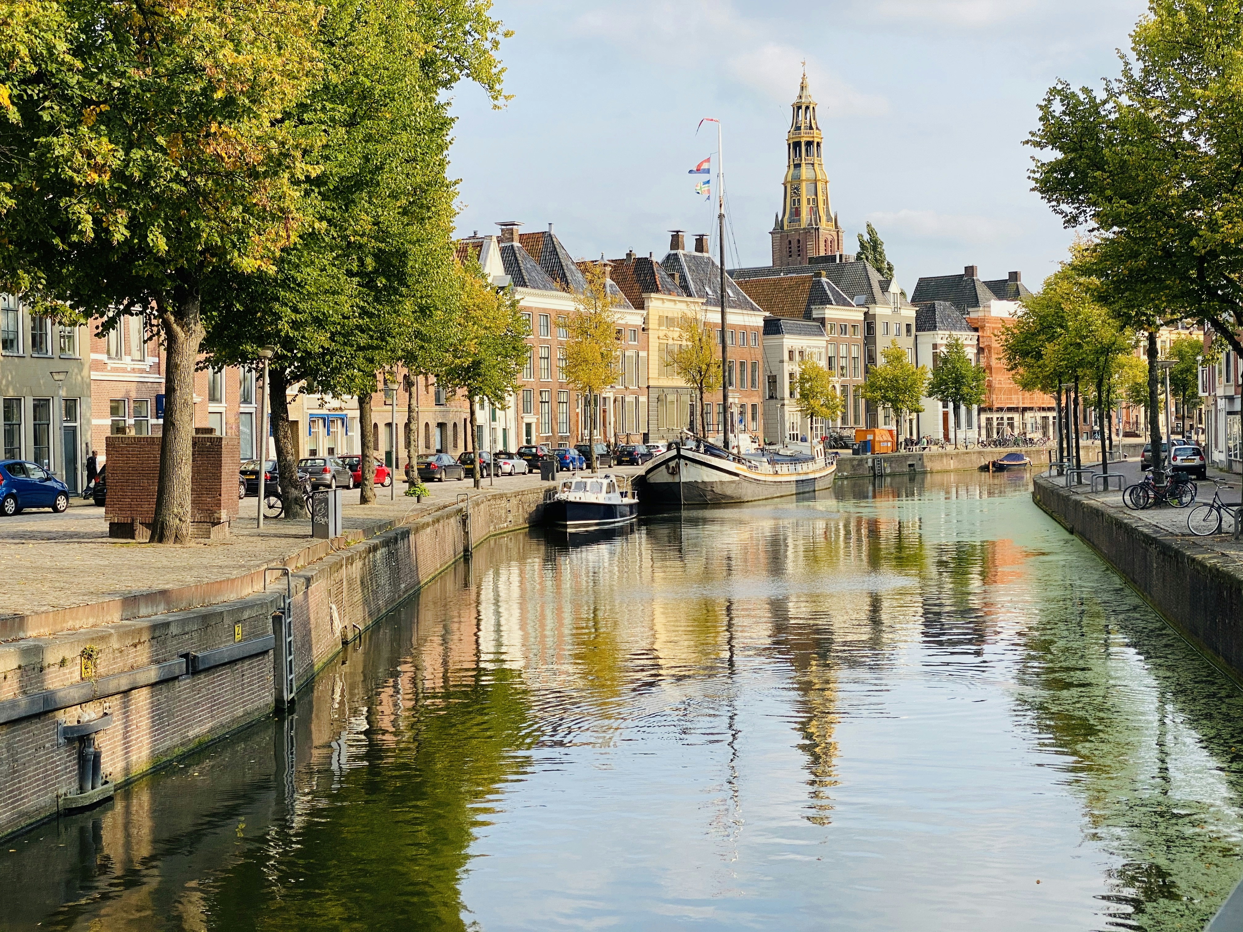 boat on river near trees and buildings during daytime