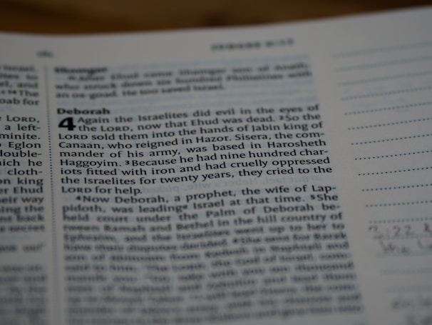 A close-up view of a page from a book, likely the Bible, featuring text in both regular and bolded font. The bolded section highlights the title 'Deborah,' followed by numbered verses. The surrounding text includes both narrative content and chapter and verse numbers.