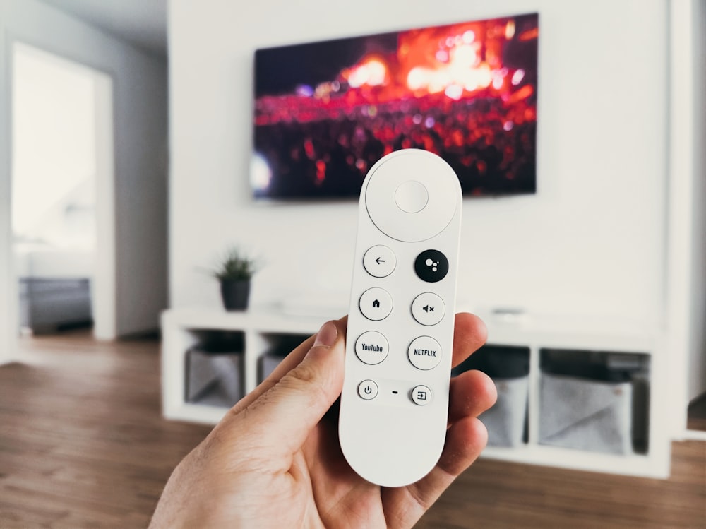 person holding white remote control
