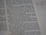 A close-up view of a page from a book, featuring clearly printed text on the left and faint handwritten notes on the right. The text discusses historical events and figures. The page is accompanied by lined sections for annotations.