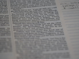 A close-up view of a page from a book, featuring clearly printed text on the left and faint handwritten notes on the right. The text discusses historical events and figures. The page is accompanied by lined sections for annotations.