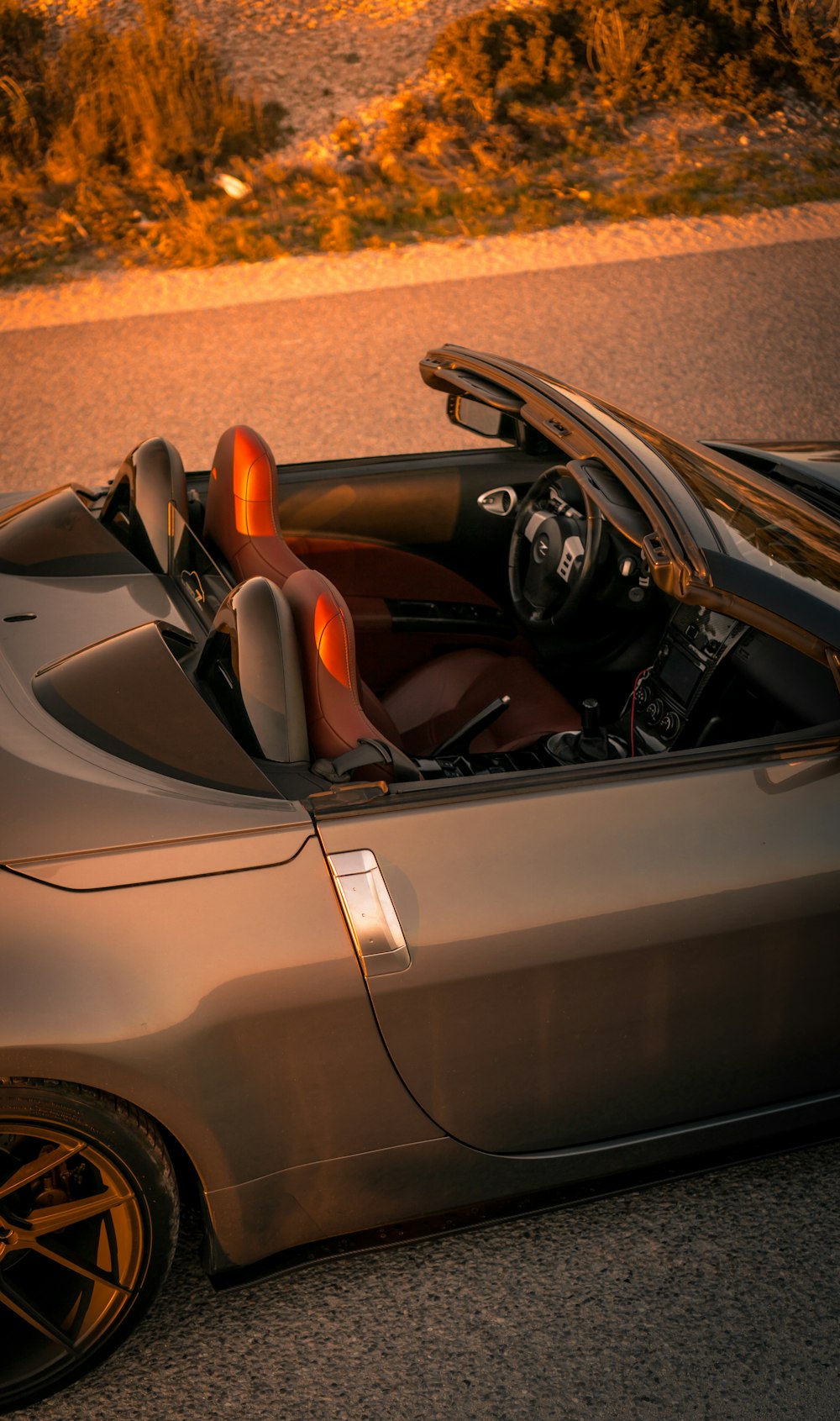 Coche descapotable plateado con volante marrón y negro