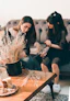 2 women sitting on sofa