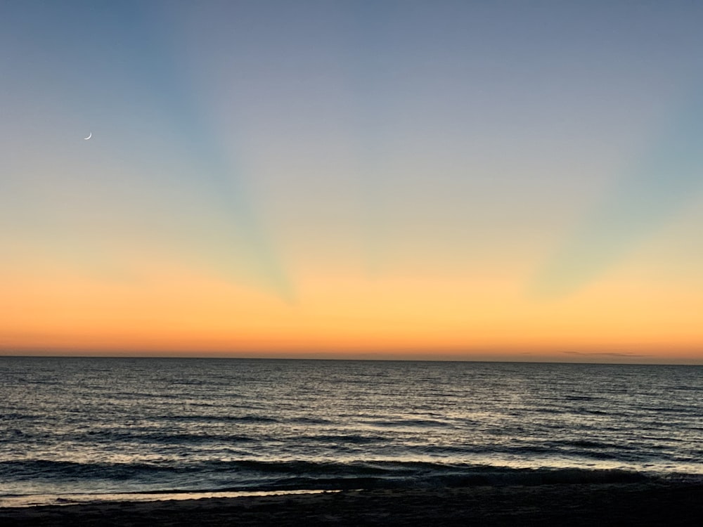 body of water during sunset