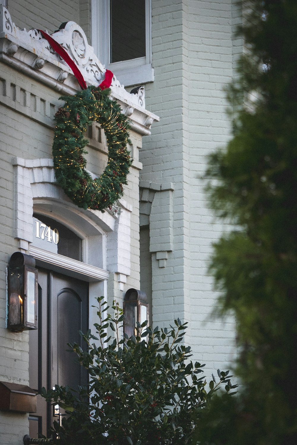 green wreath hanged on white wooden door