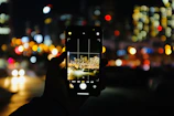 Close-up of a sleek smartphone displaying a vibrant cityscape at night