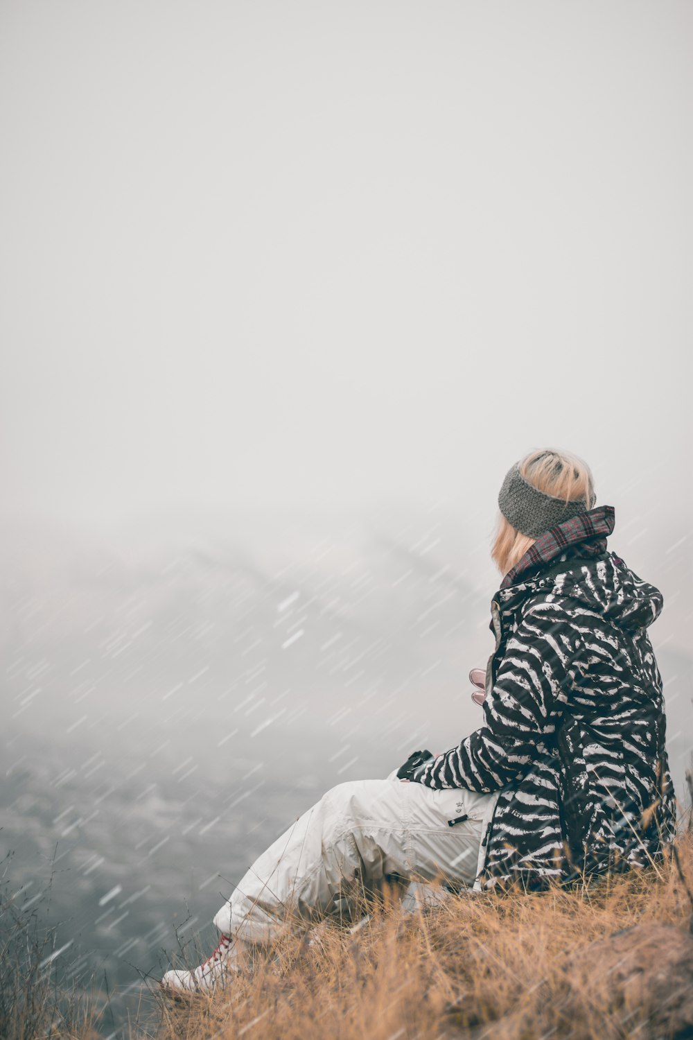 person in black and gray plaid hoodie standing on white textile