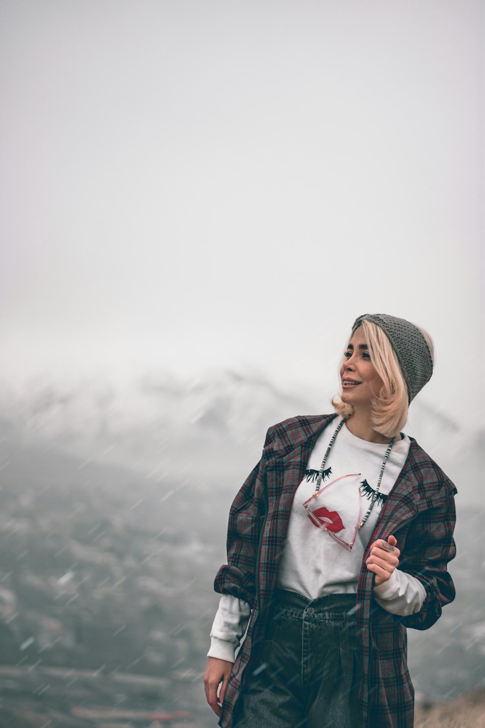 woman in black and red plaid jacket wearing gray knit cap