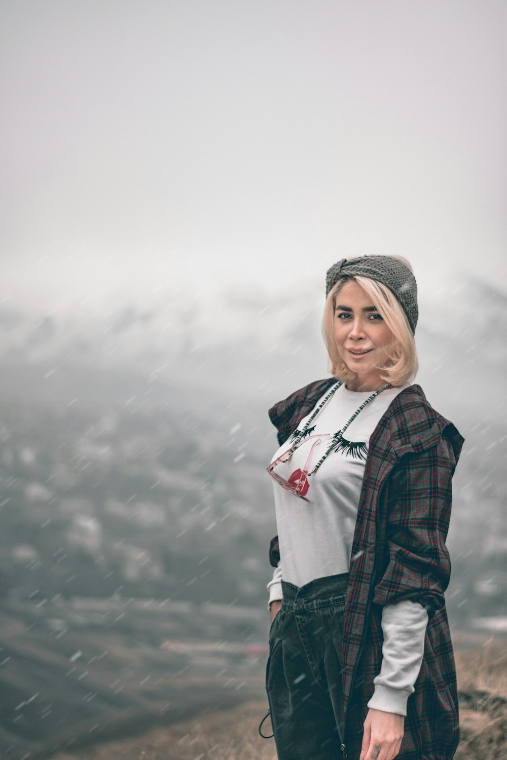 woman in black and red plaid jacket standing on snow covered ground