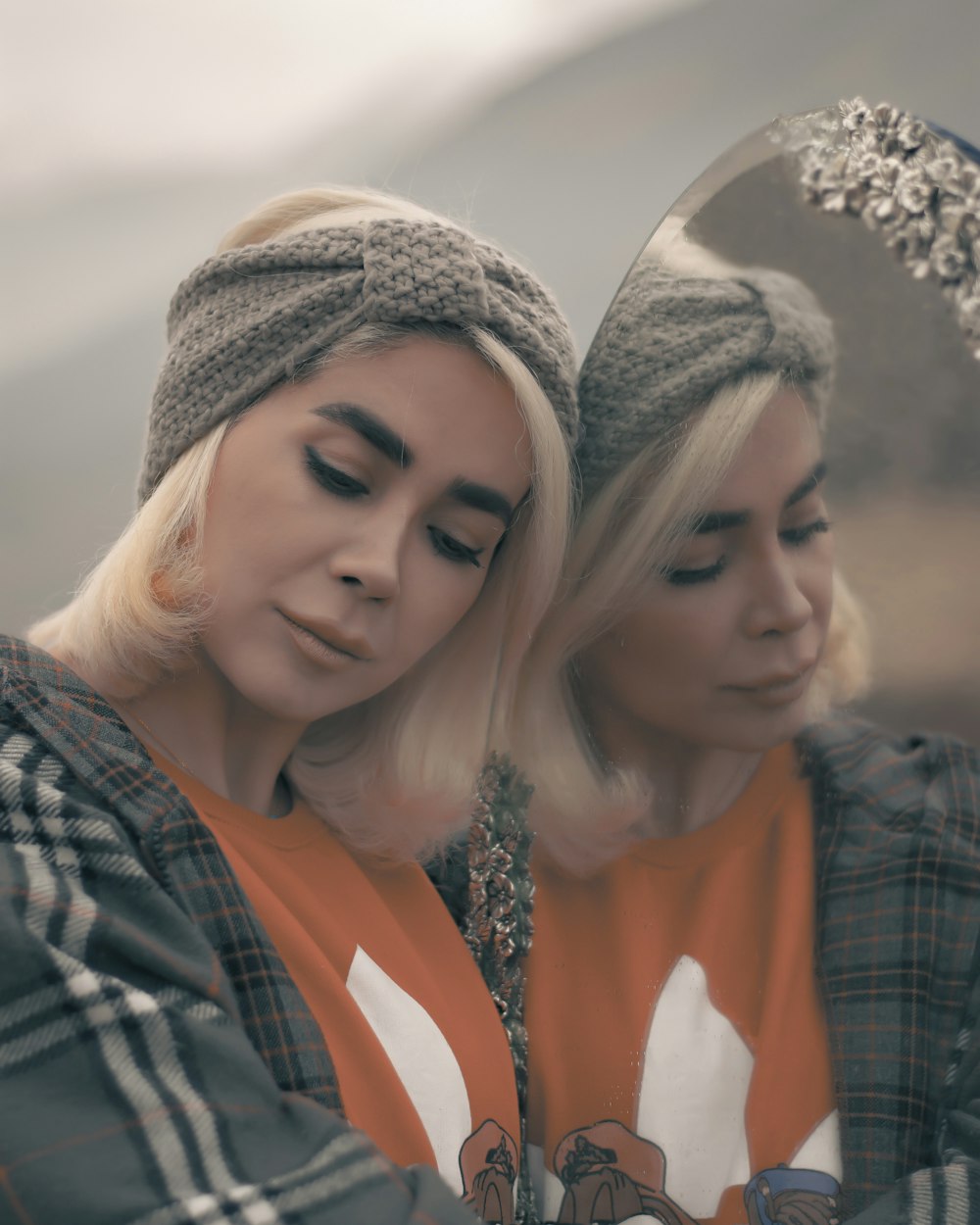 woman in gray knit cap beside woman in orange shirt