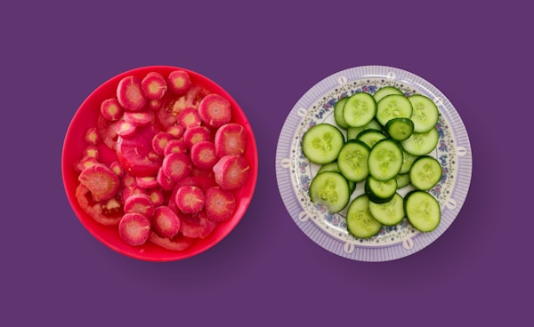 Sliced cucumber and tomato on red round ceramic plate