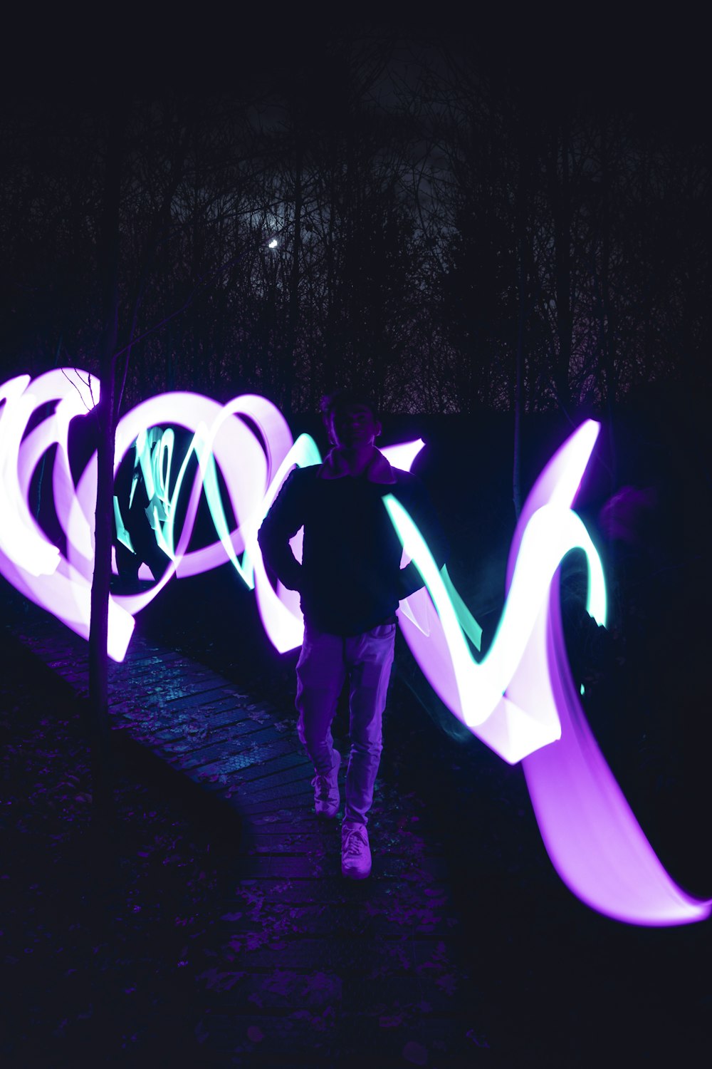 man and woman walking on street with purple lights