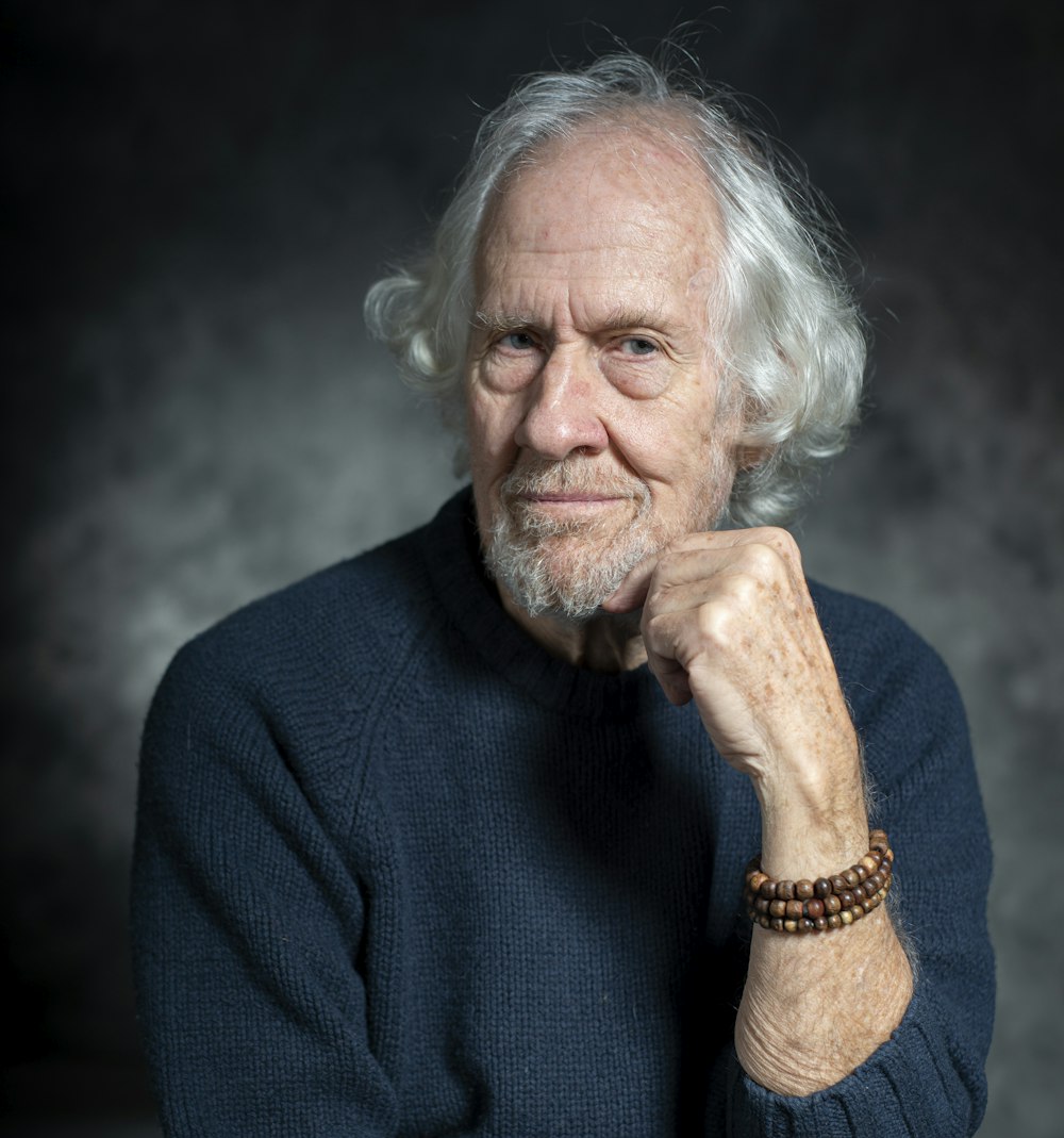 man in blue sweater with white hair